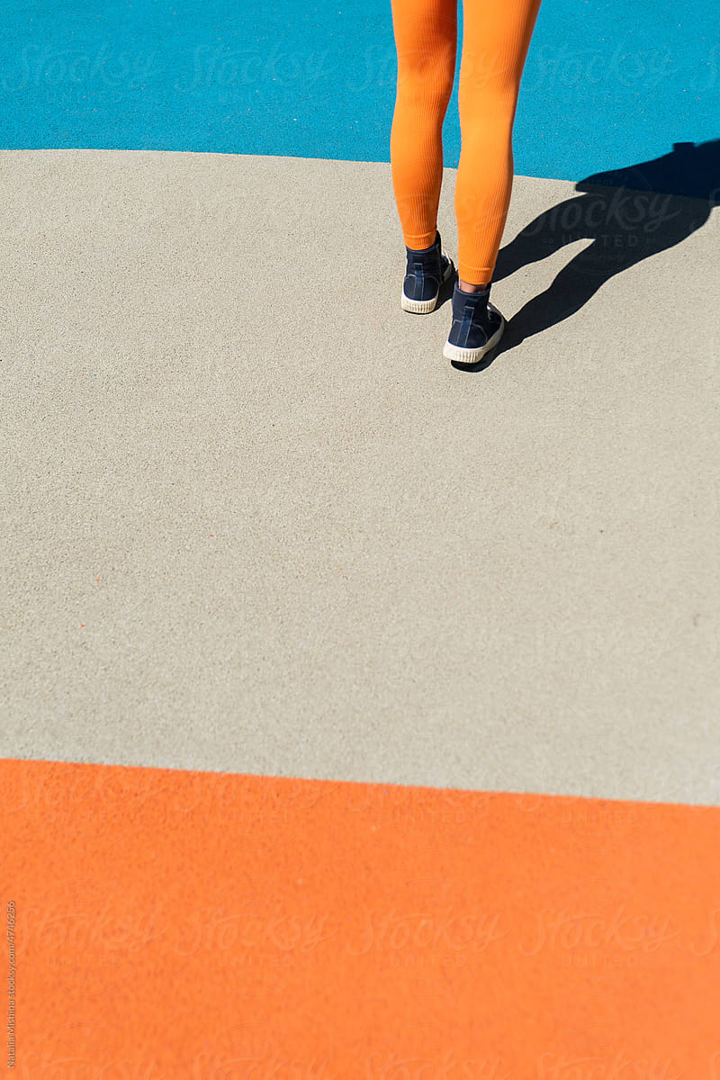 The legs of a girl in orange leggings.