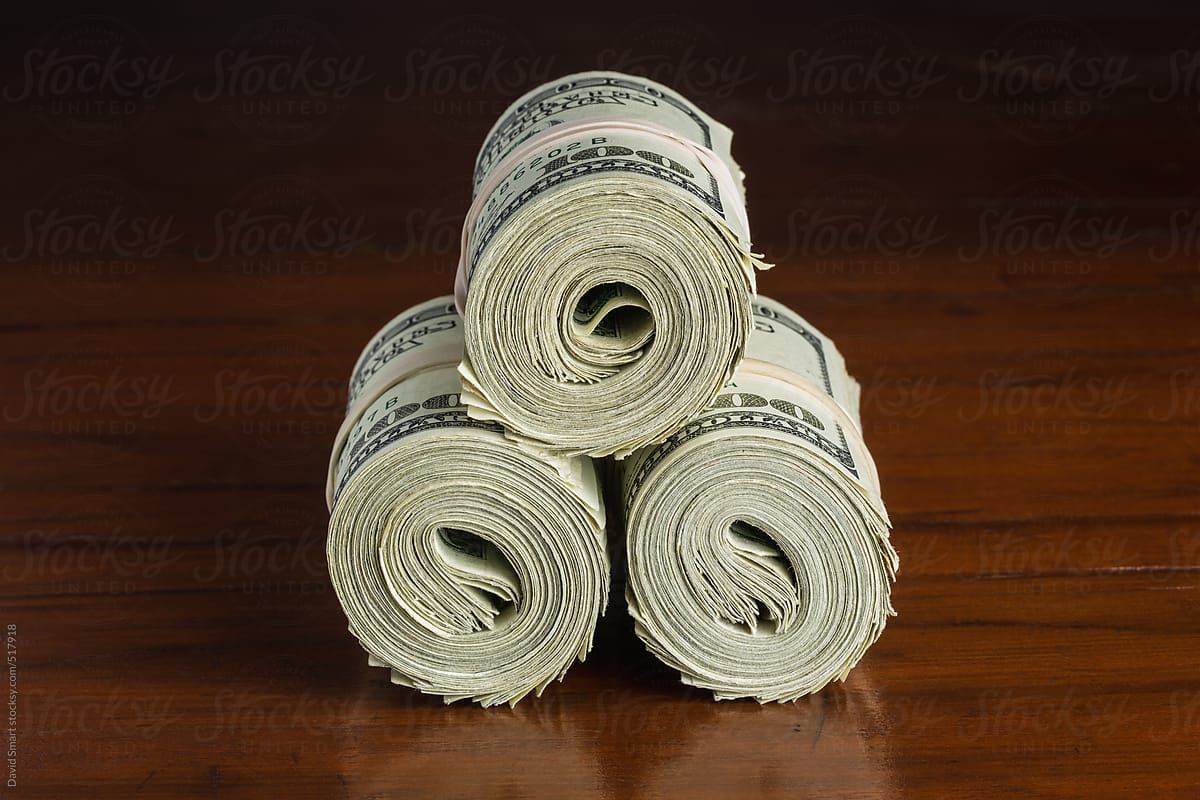 One hundred dollar bills on wooden table