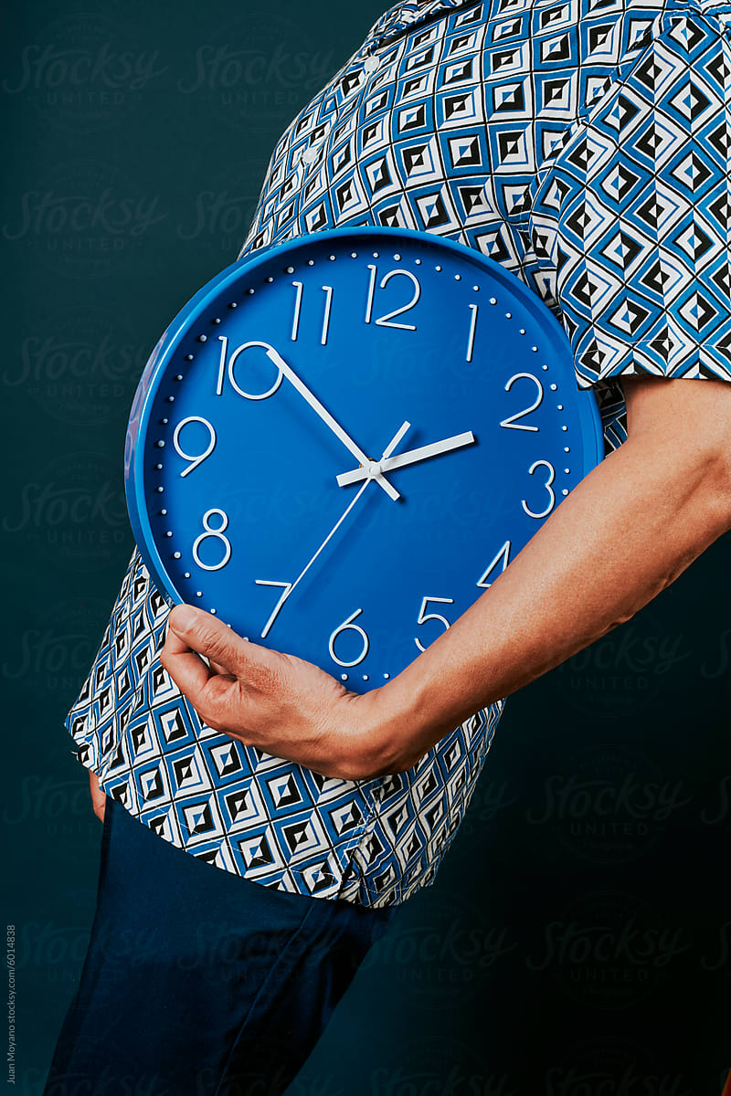 man with a blue clock under his arm