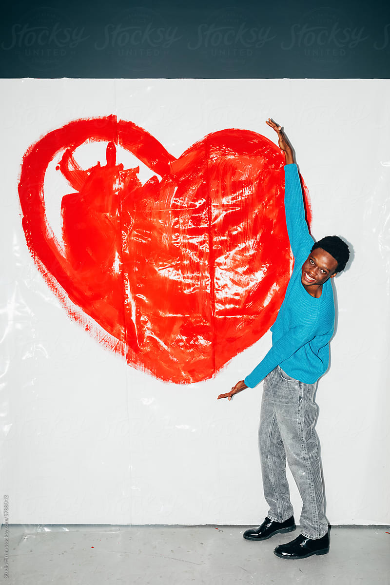Man posing in front of big heart