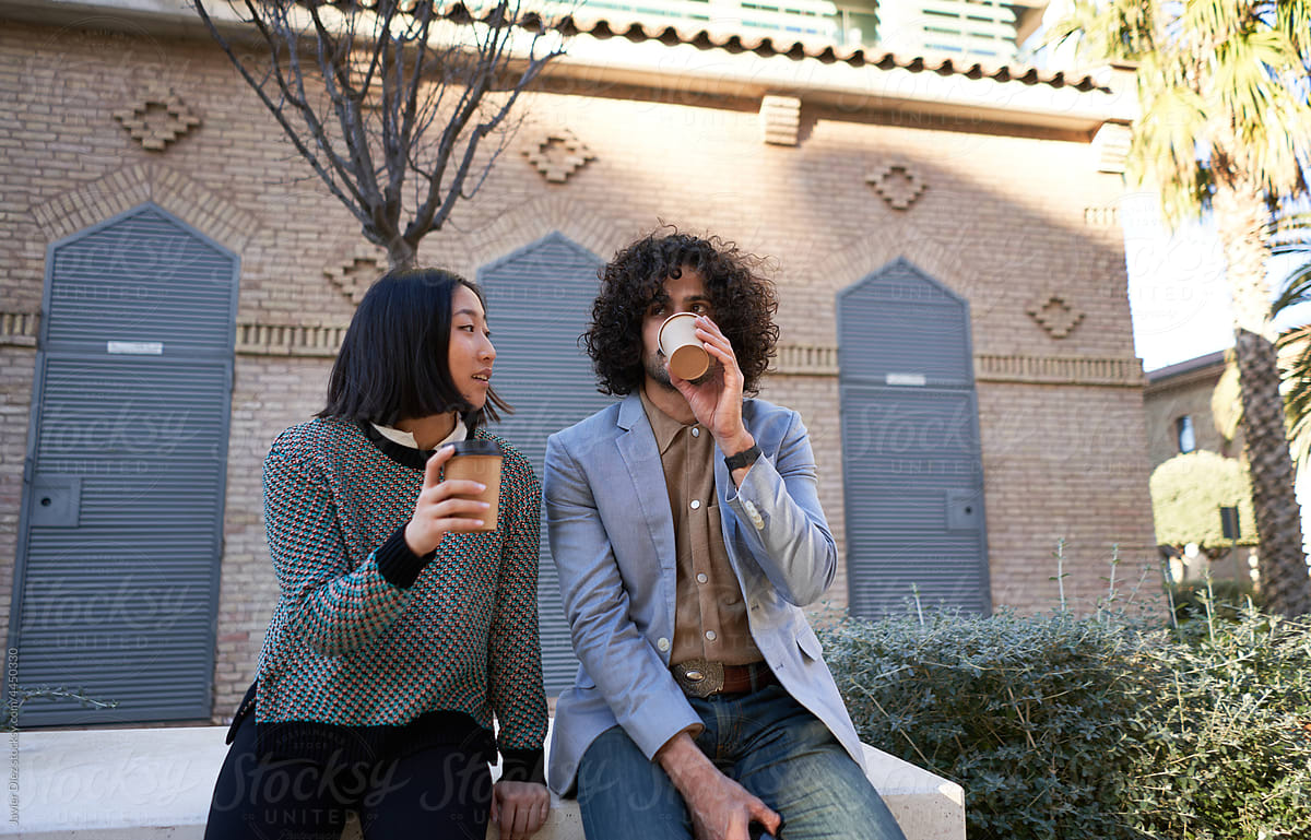 Colleagues drinking coffee on street together
