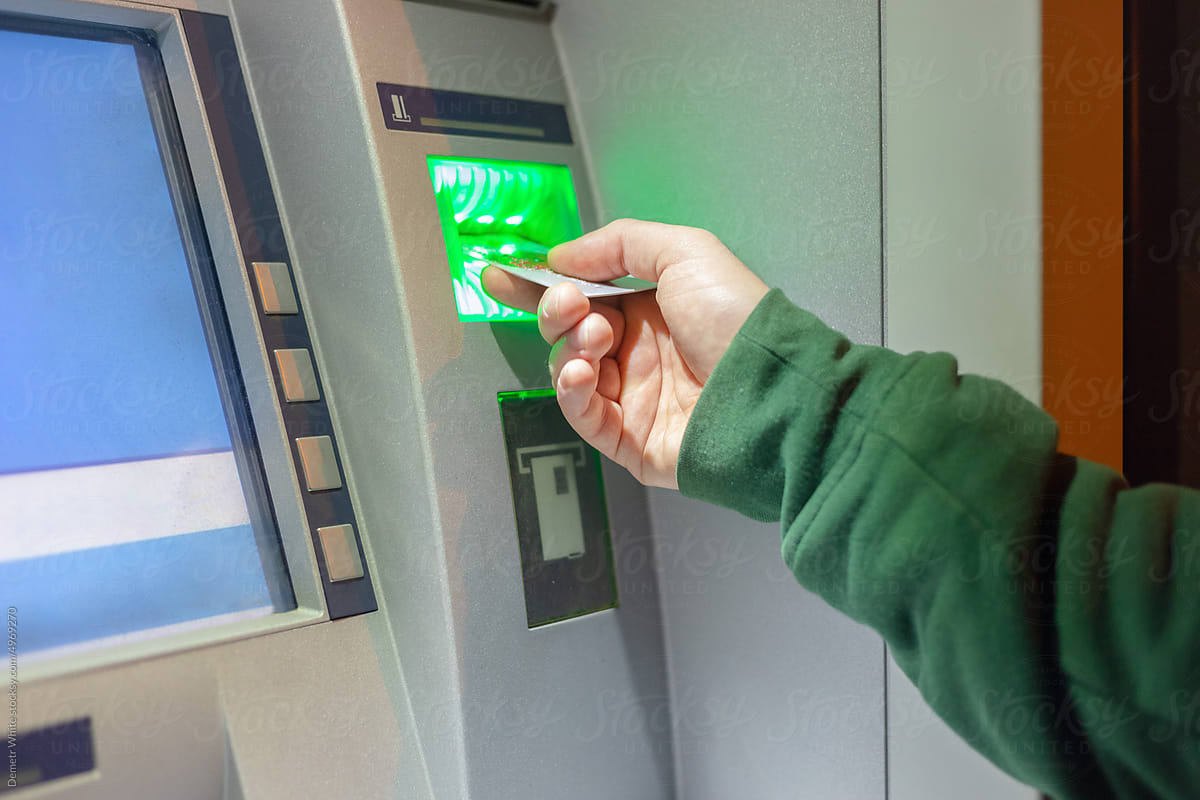 man inserting a credit card into an ATM