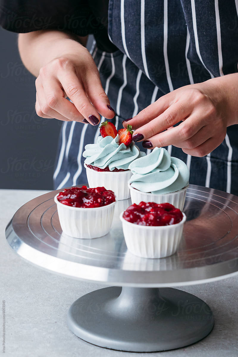 Pastry Chef Decorating Cupcakes With Berries