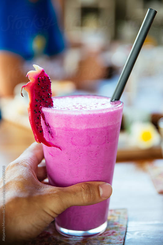 tasty and fresh smoothie decorated with dragon fruit slice and straw.Bokeh