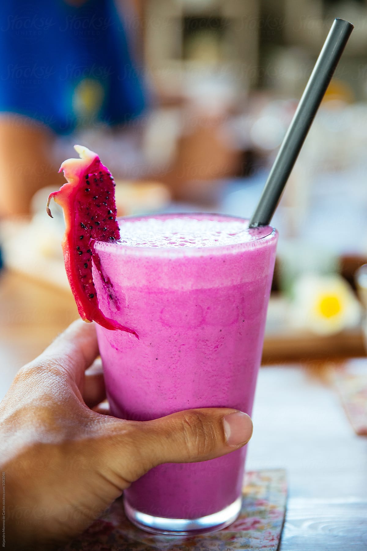 Tasty and fresh smoothie decorated with dragon fruit slice and straw.Bokeh