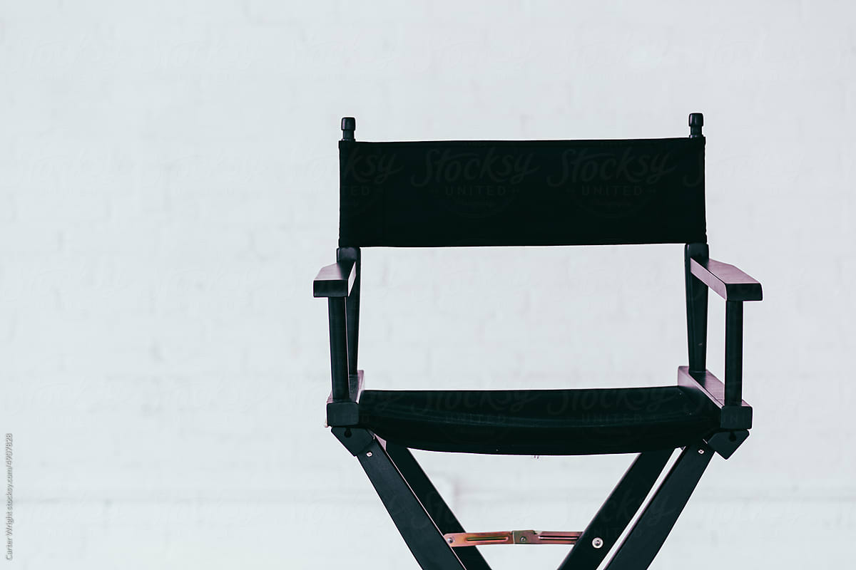 Close up of a black director\'s chair in a white brick warehouse