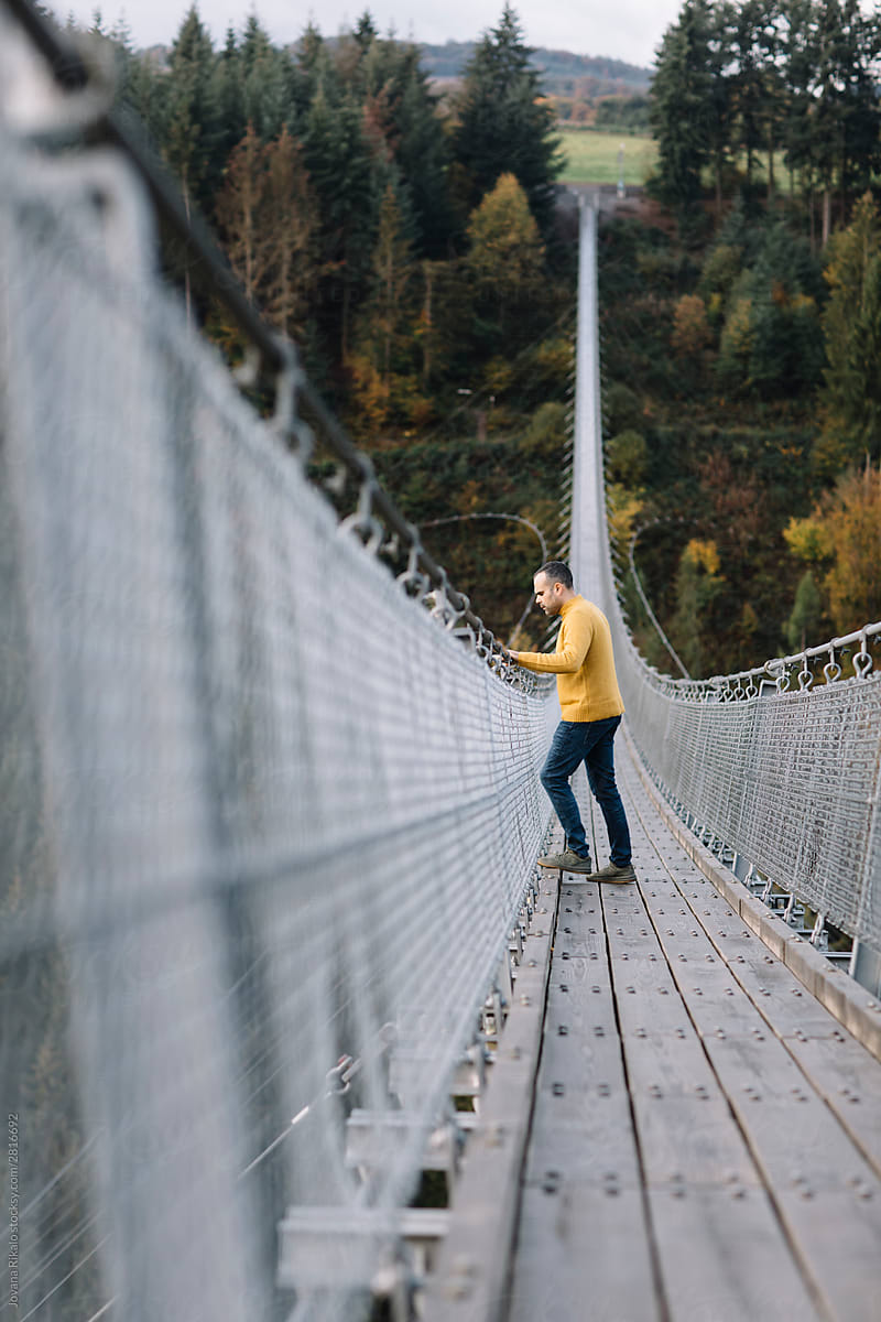 Man standing on a suspension bridge