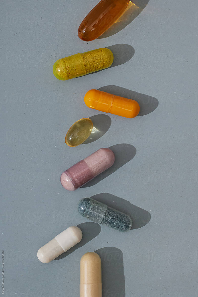 Colorful Supplement Pills on Light Blue Background