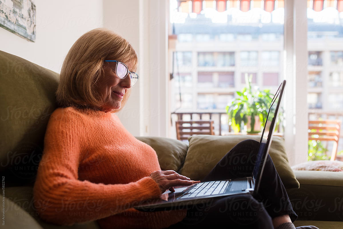 Mature woman managing online banking with laptop