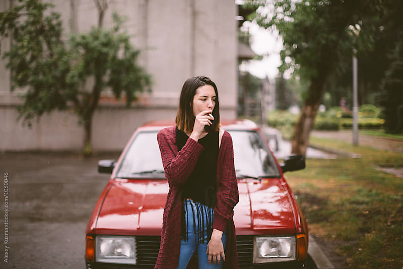 portrait of real young woman with red car