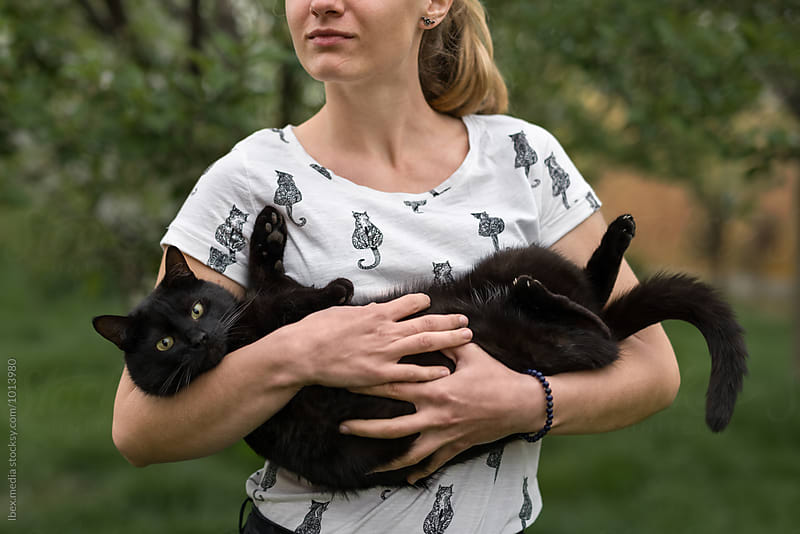 Woman holding her black cat