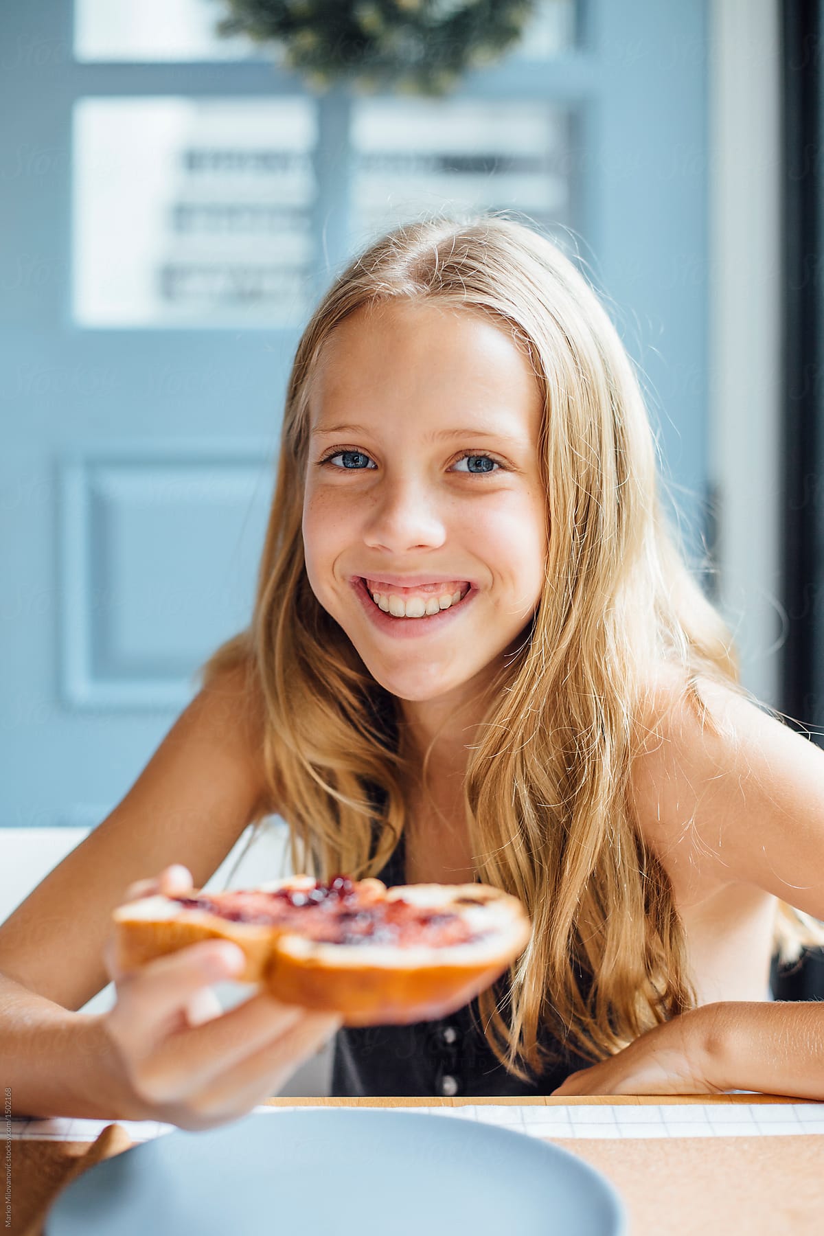 Young girl holding toast with jam