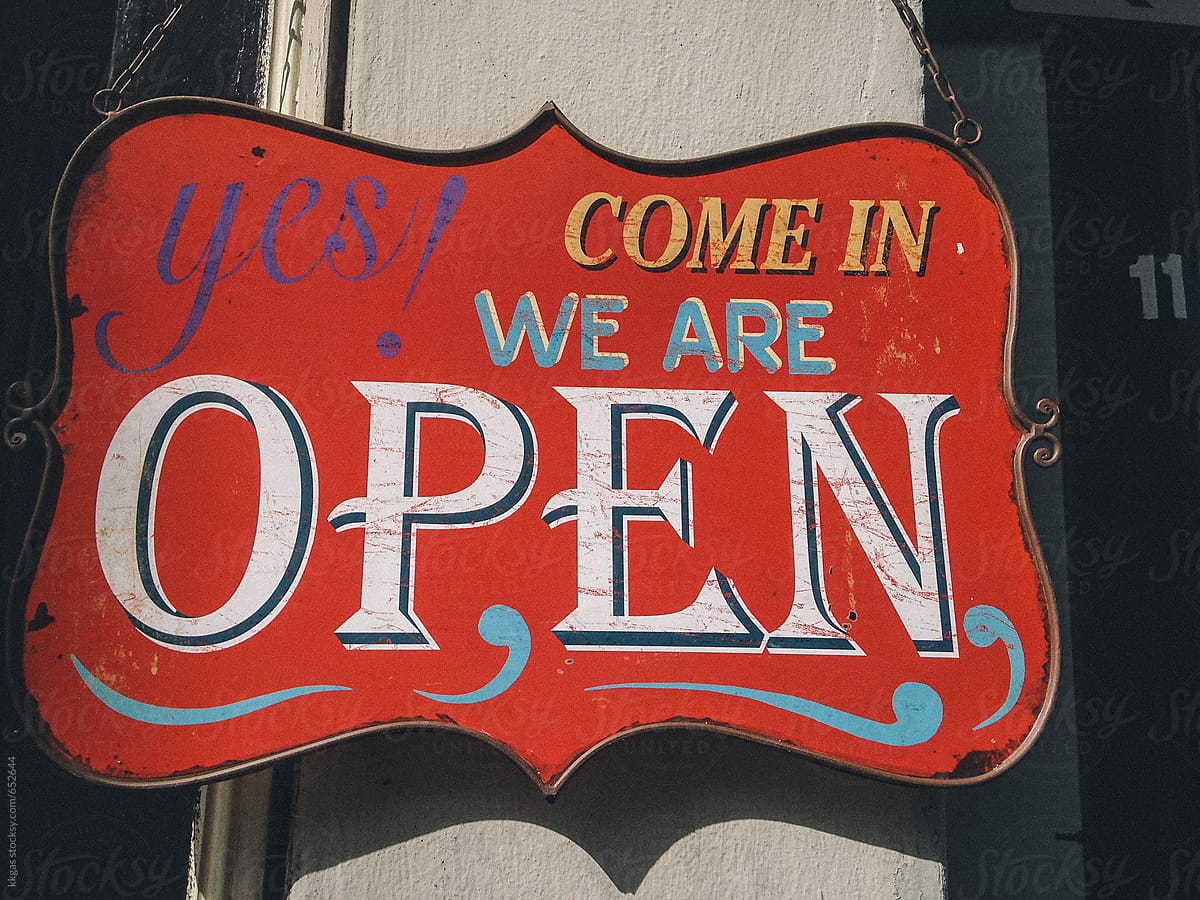 Vintage tin shop sign indicating a business is open.