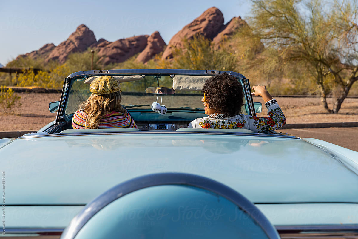Happy Friends Talking in Vintage car in Arizona with fuzzy dice