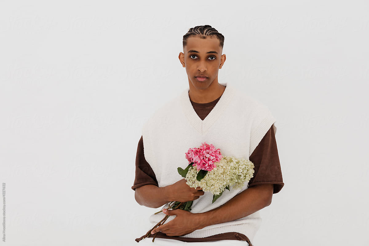 Upset black male sitting with bouquet