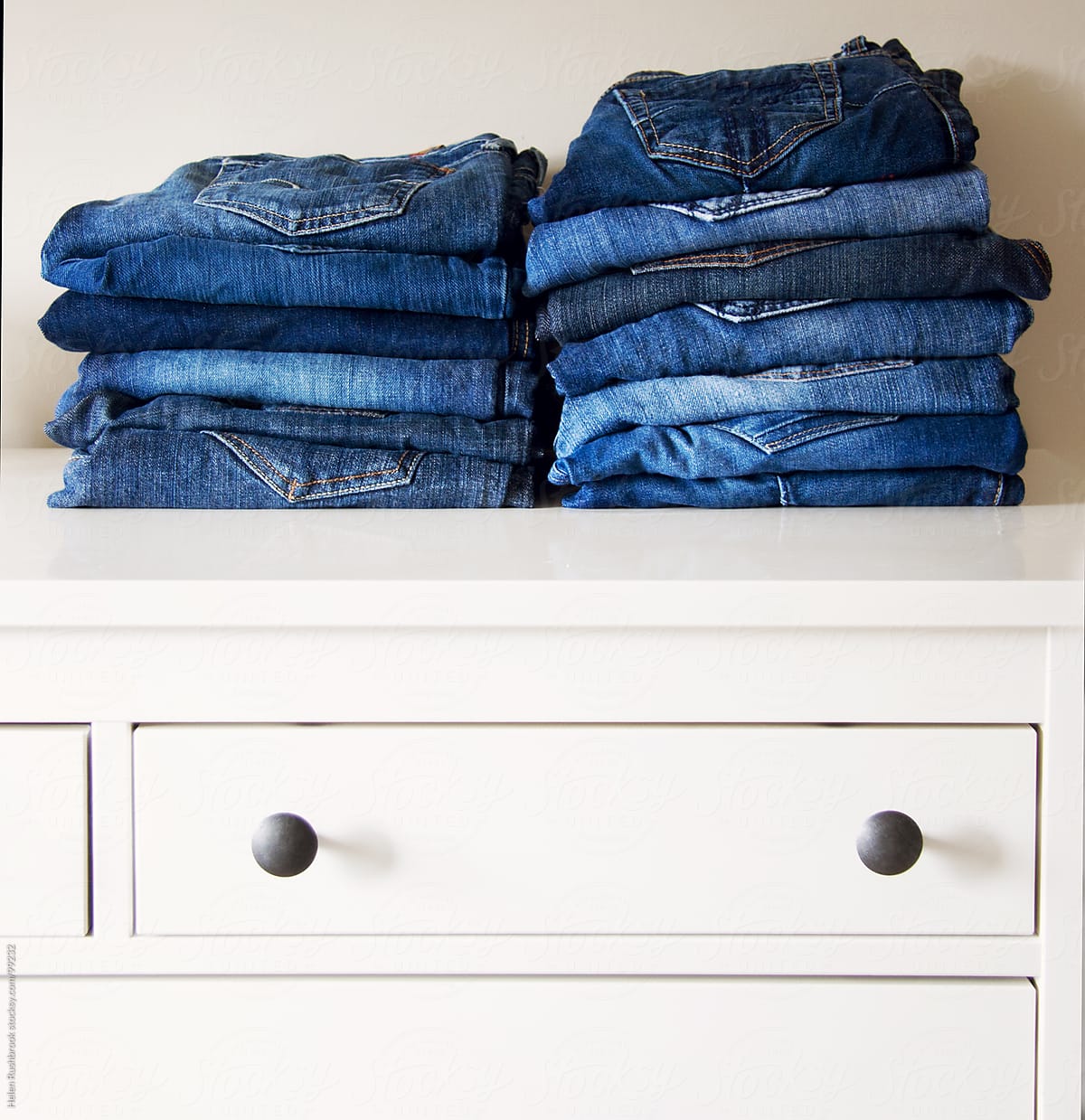 Jeans stacked on a dresser