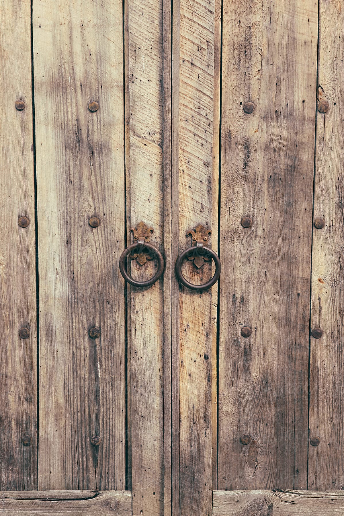 Weathered rustic wood door with metal handles