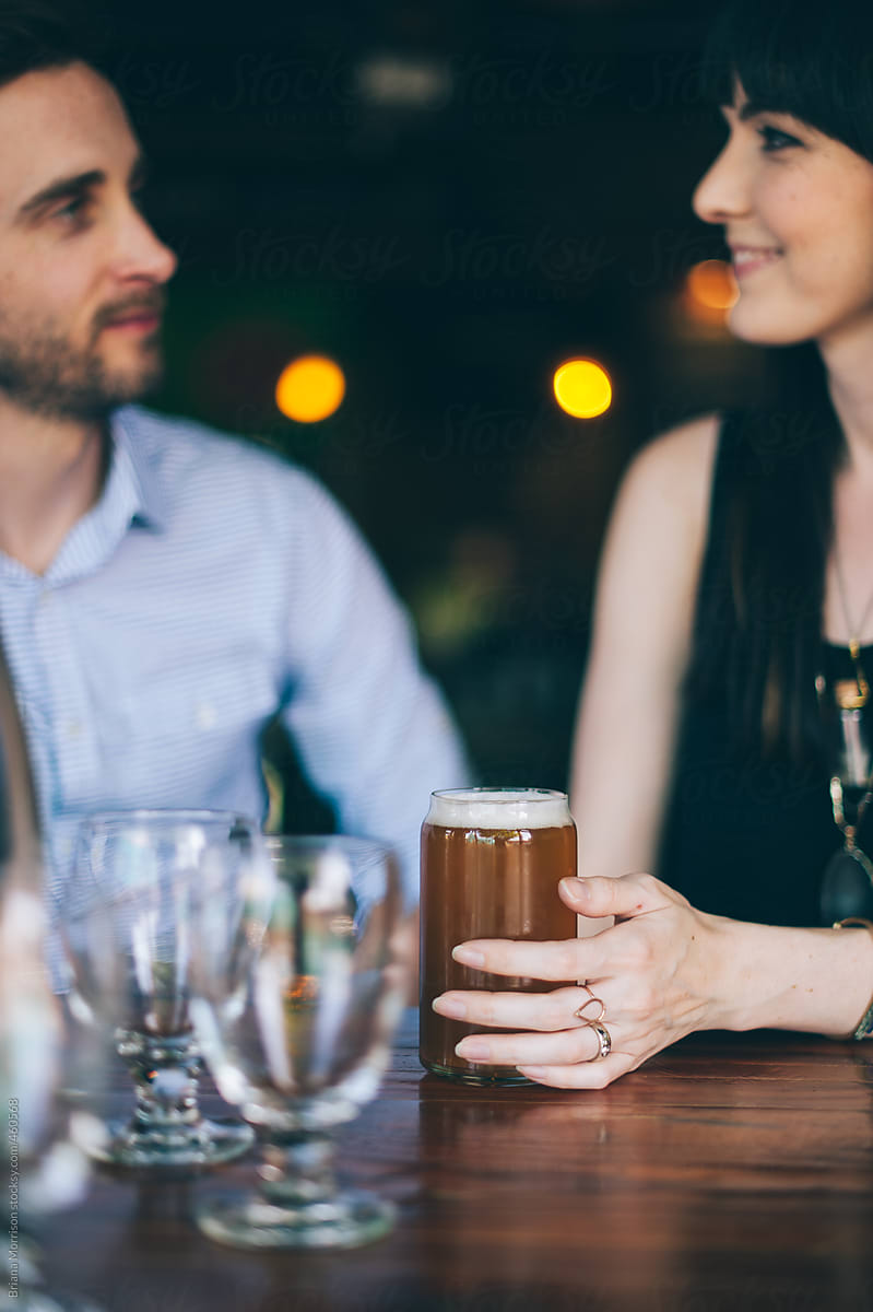 A Man and a Woman Sharing a Beer in a Bar