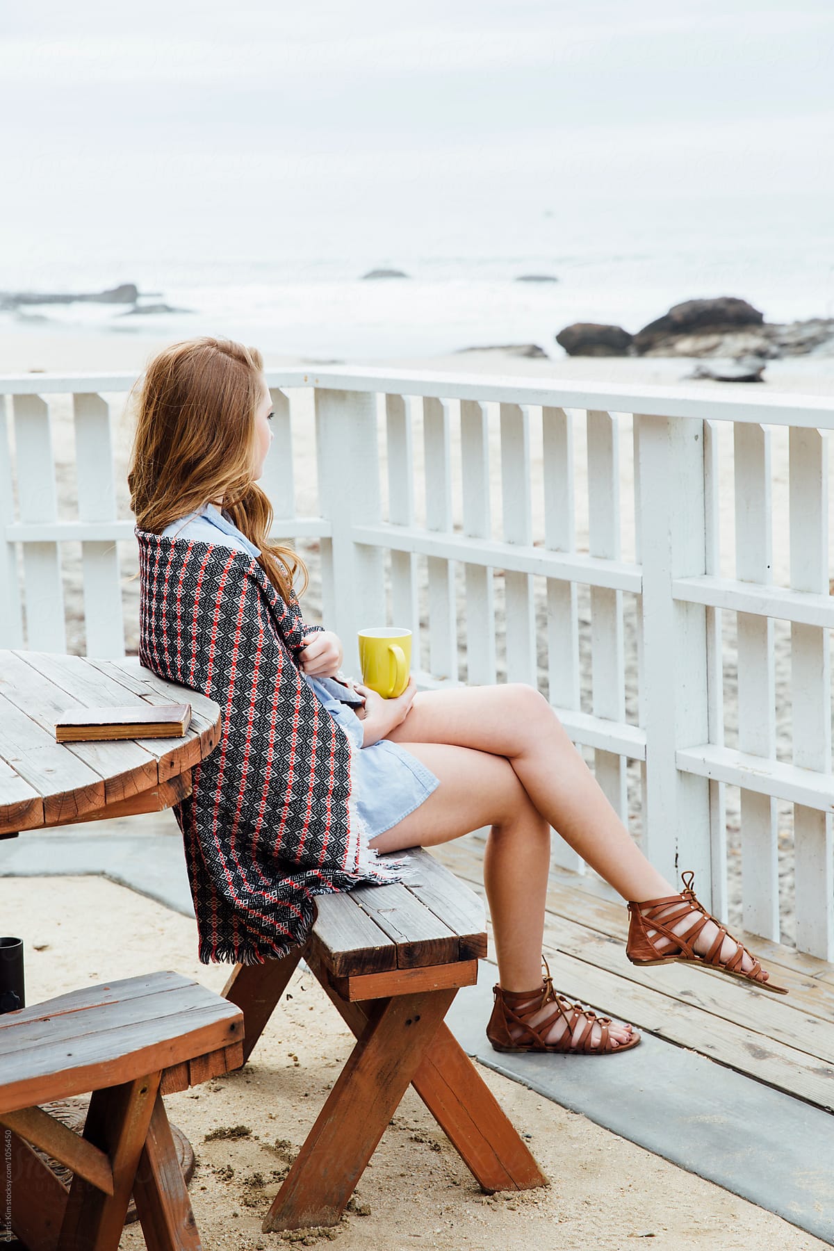 Woman Sitting On Bench Overlooking The Ocean By Stocksy Contributor