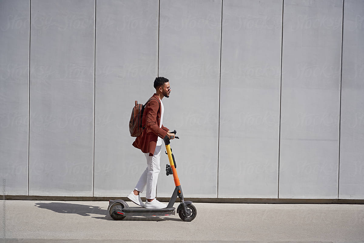 Trendy Guy Riding Electric Scooter Fast