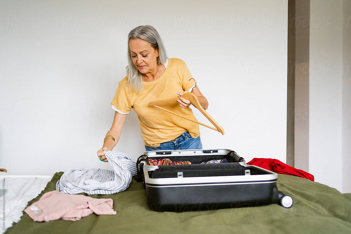 Mature woman preparing suitcase