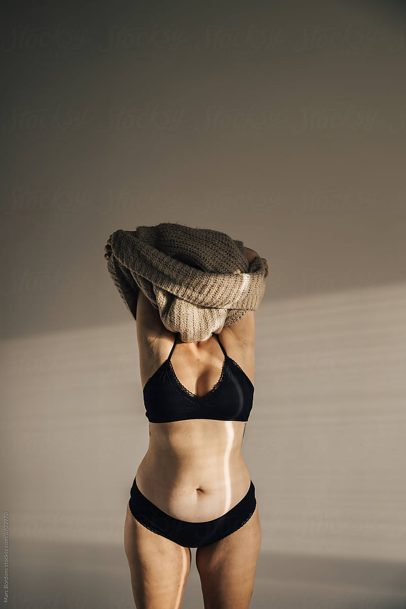 a woman taking off a sweater.