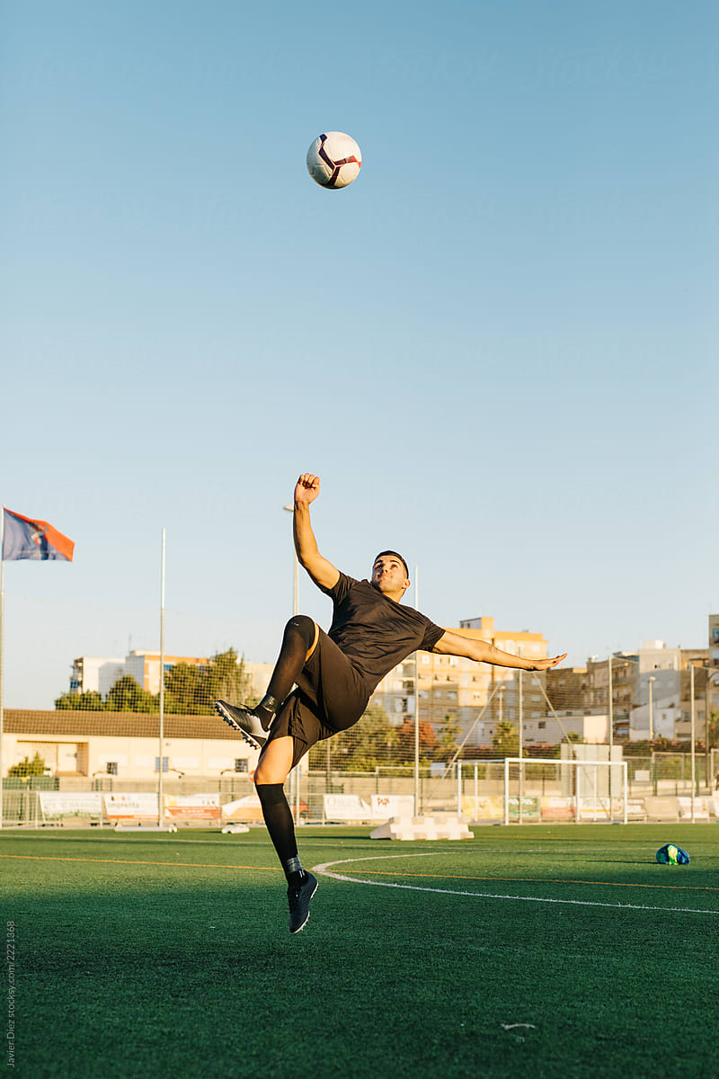 Soccer player jumping and kicking ball