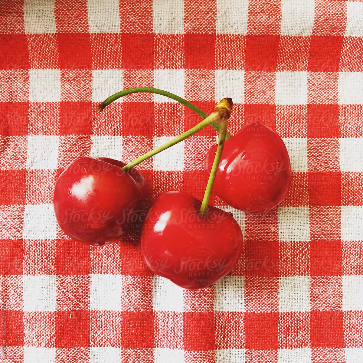 Cherries on red checkered tablecloth
