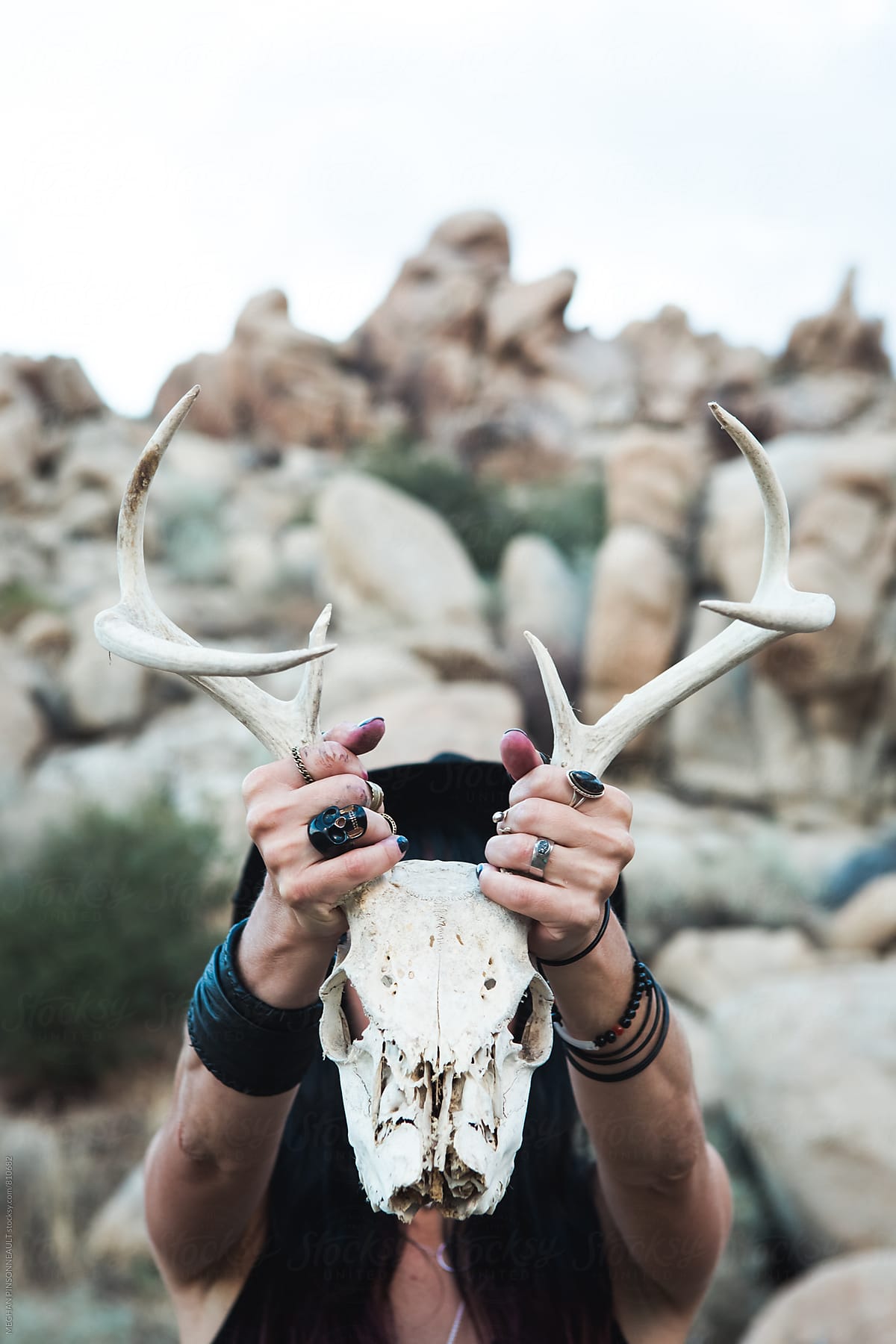 Woman Holding Deer Skull in Front of Face