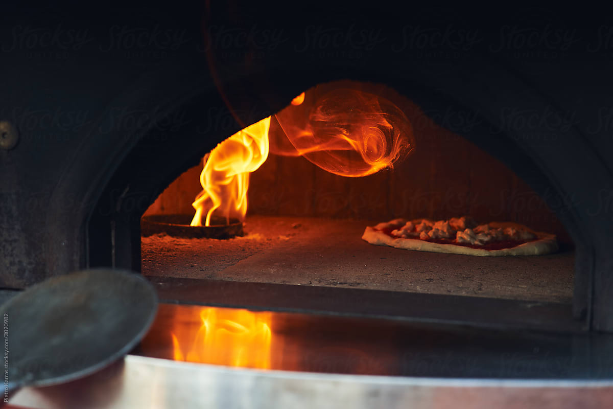 Tasty pizza cooking in big oven in restaurant