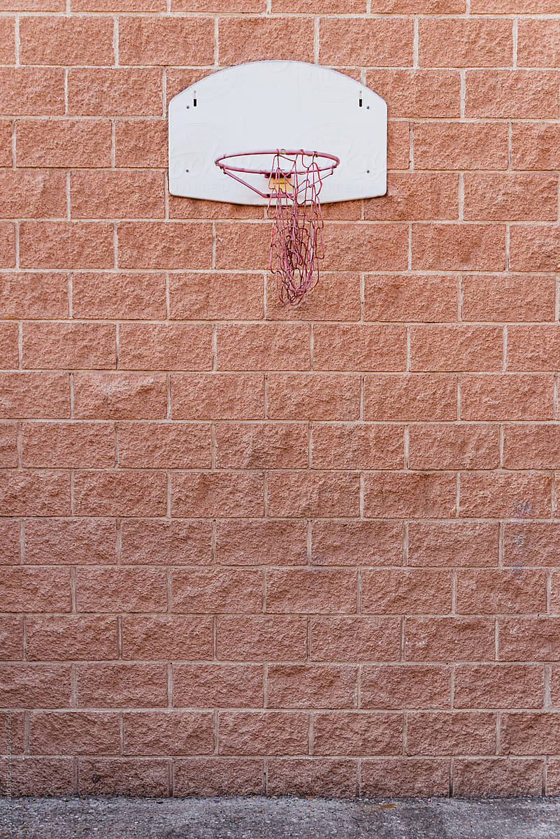 Basketball hoop on brick wall on street
