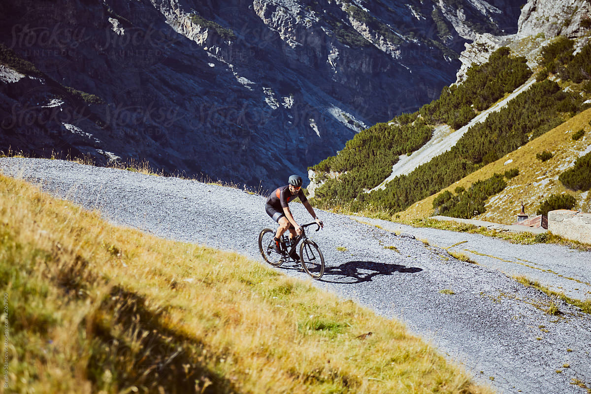 Road Cyclist riding in alps.