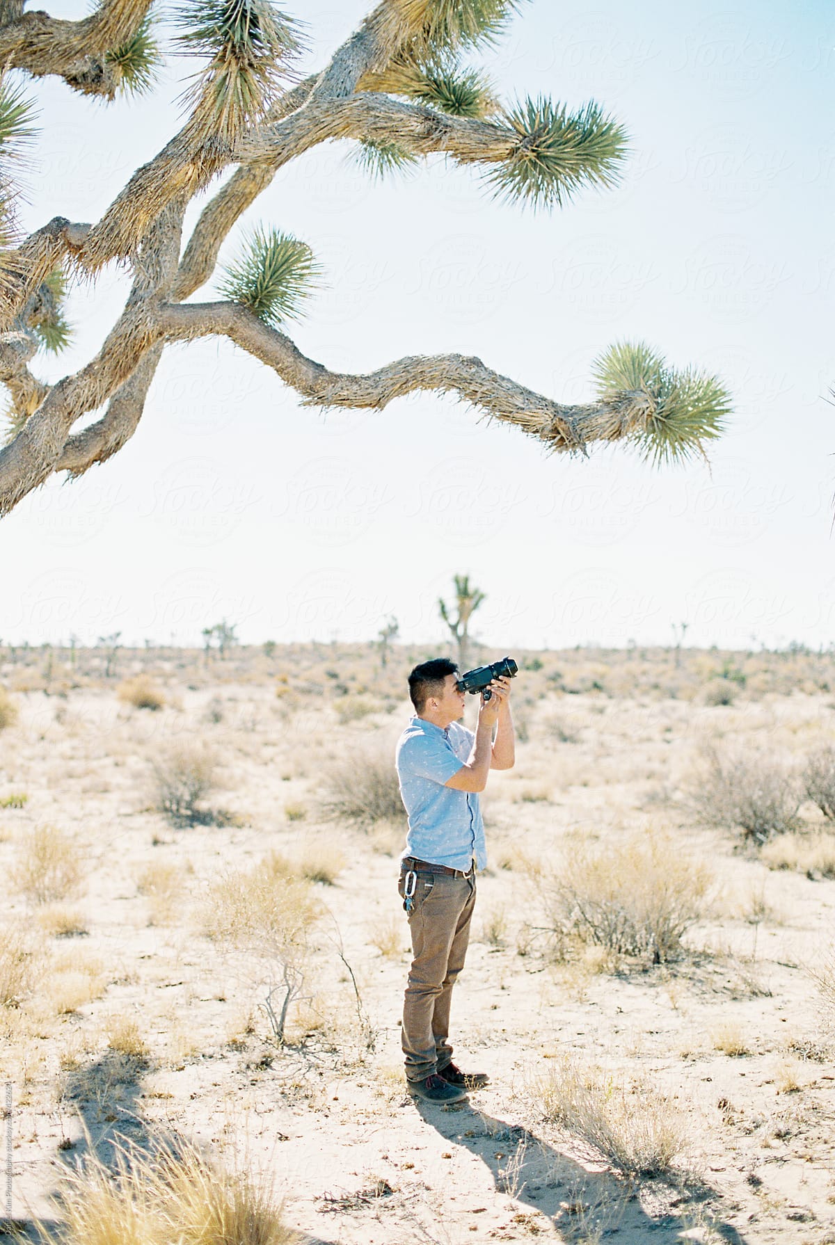 Young man taking picture in desert