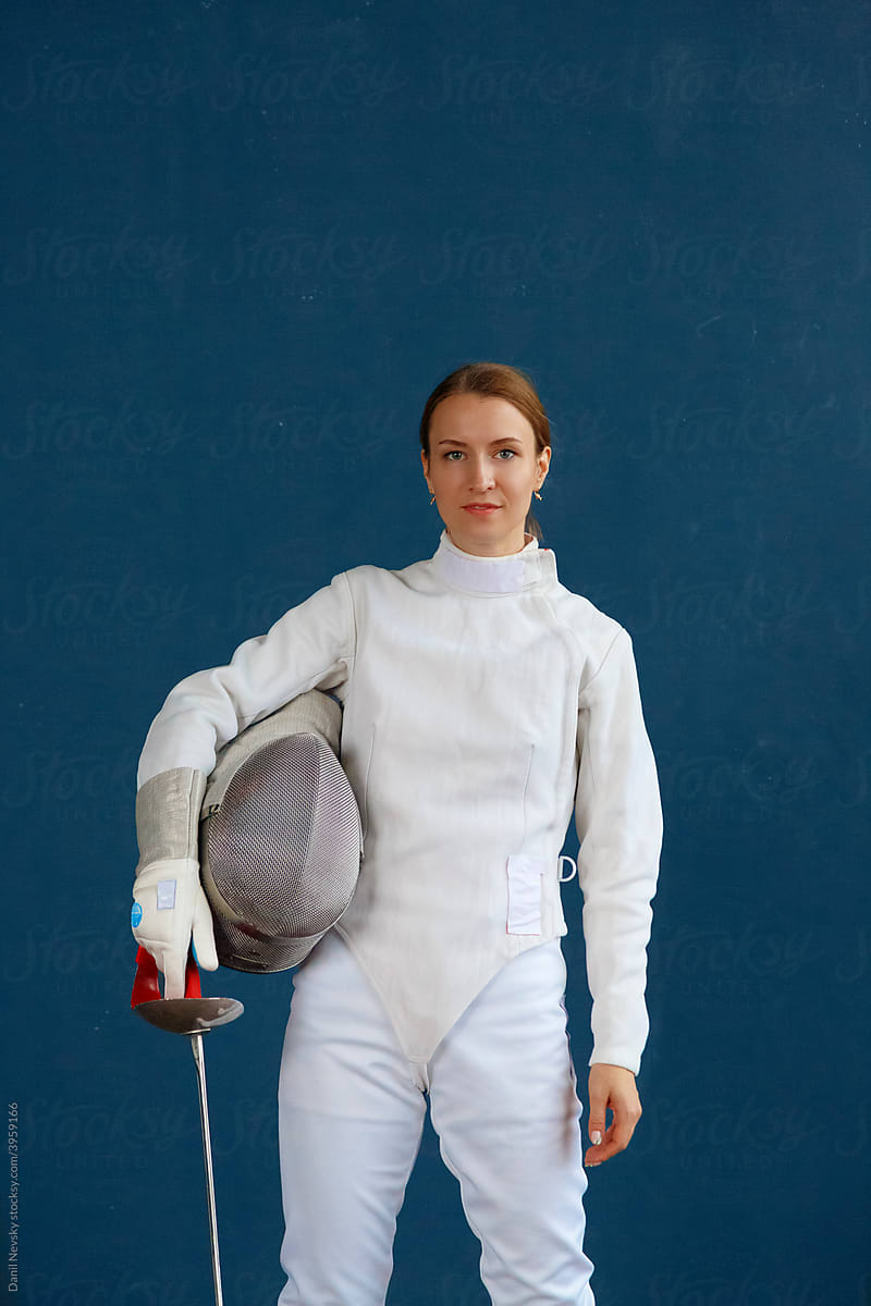 Female fencer against blue wall