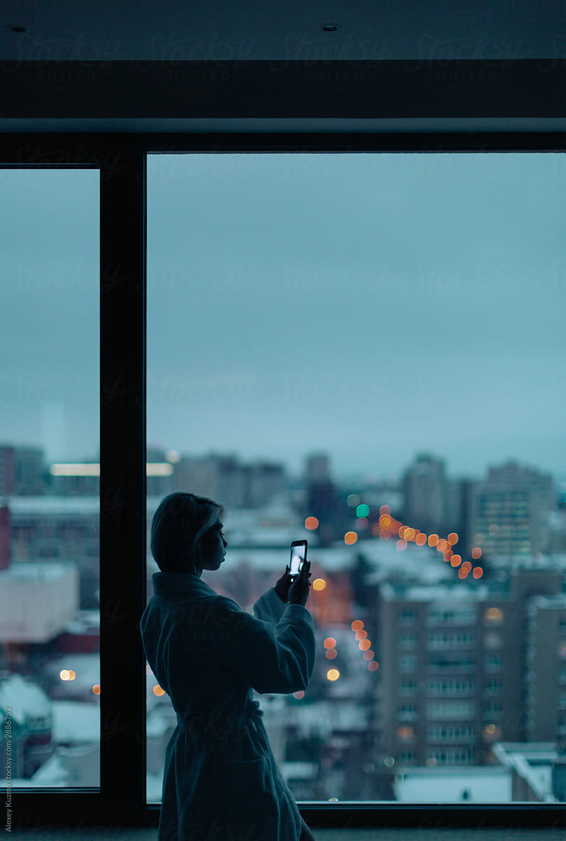 young woman near the window with cell phone