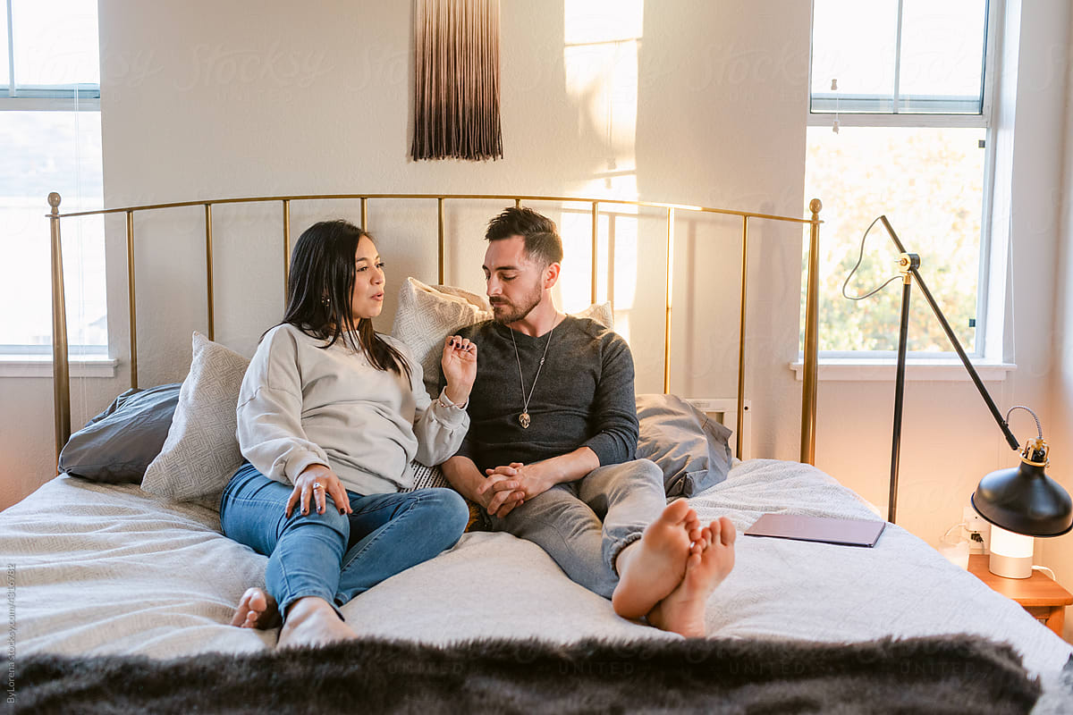 Couple in love conversing at double bedroom