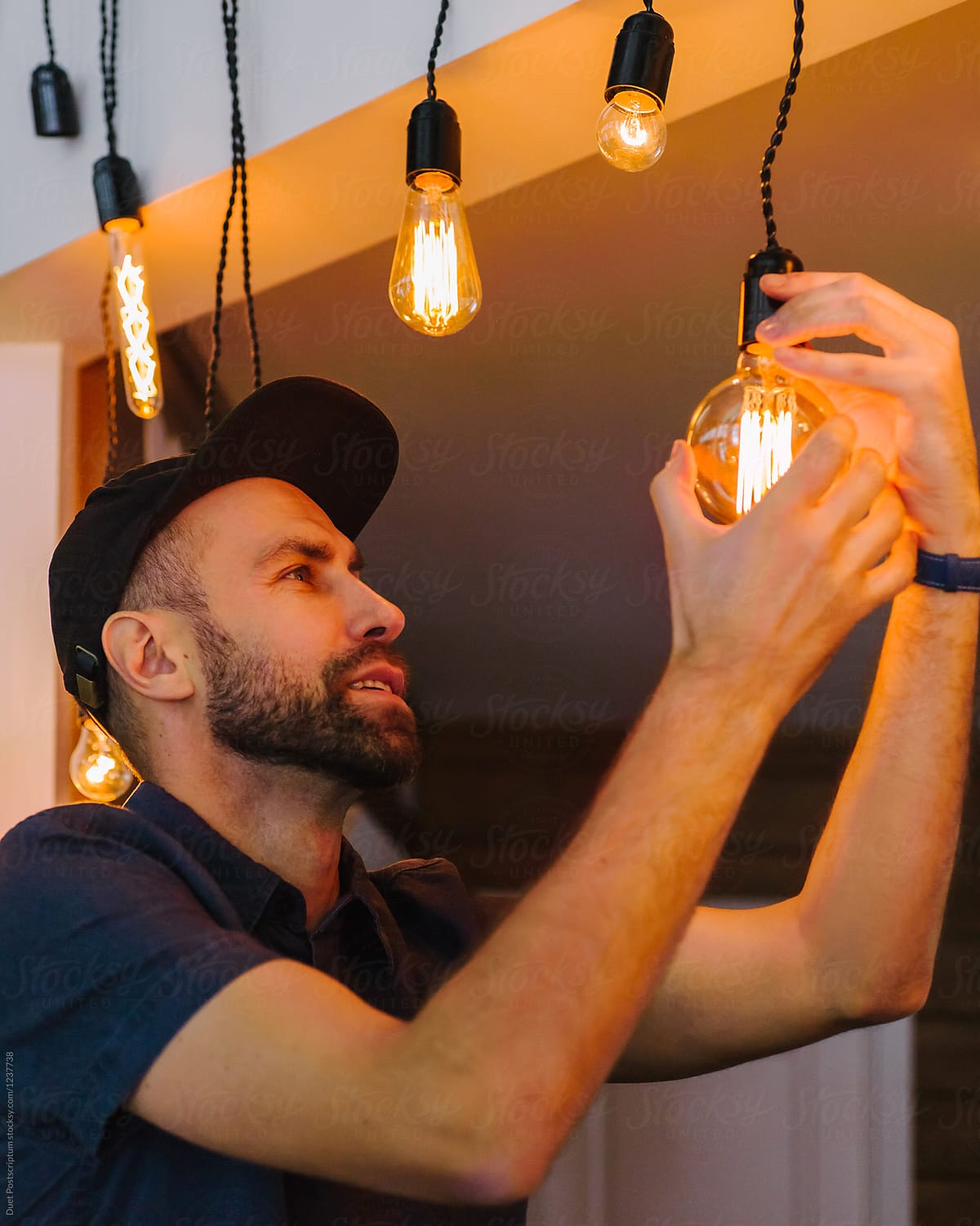 Man twisting bulb in lamp