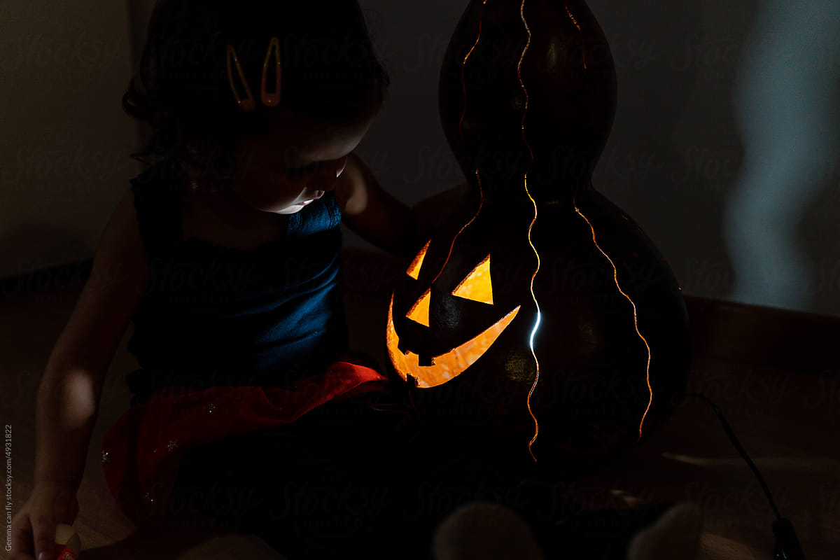 Little girl with Jack-O-Lantern water gourd for Halloween