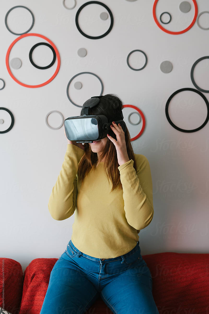 Woman exploring virtual reality on sofa