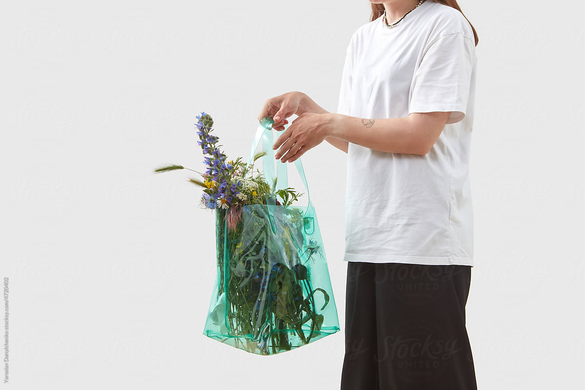 Girl with flowers in recycled bag.