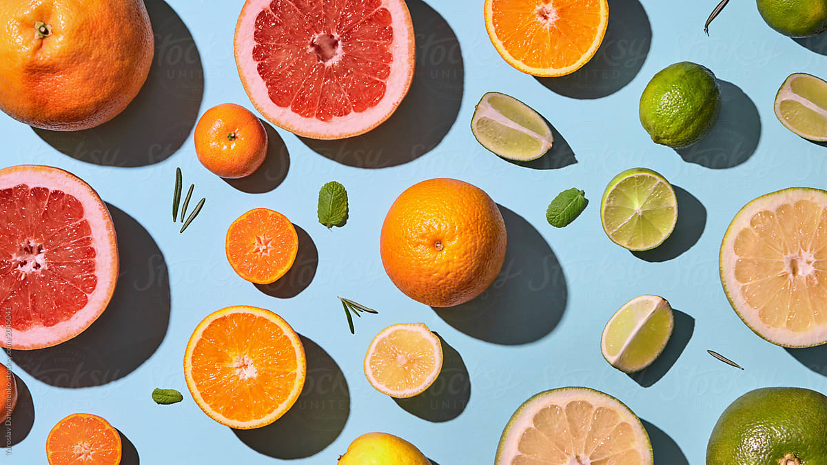 Fresh sliced citrus fruits pattern on blue background.