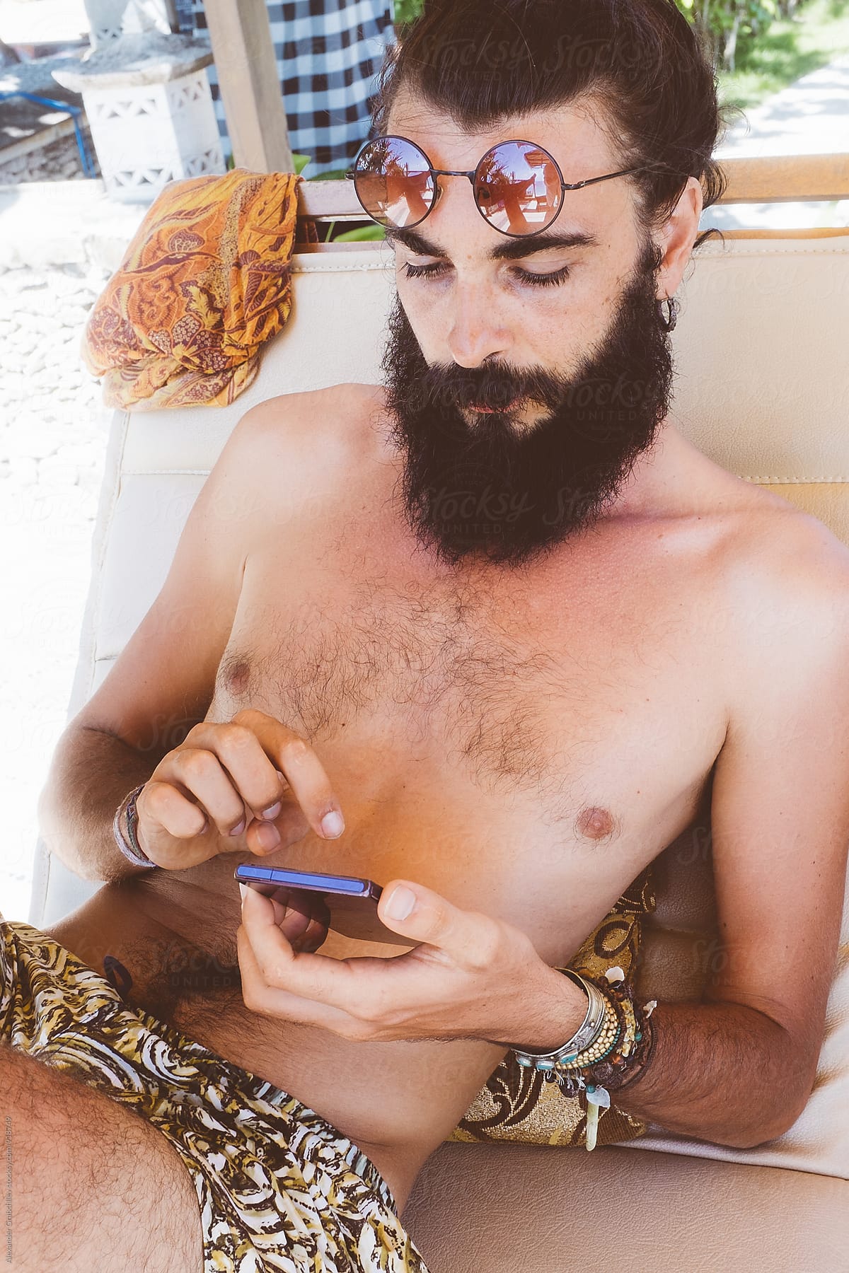 Young man using the phone on the beach