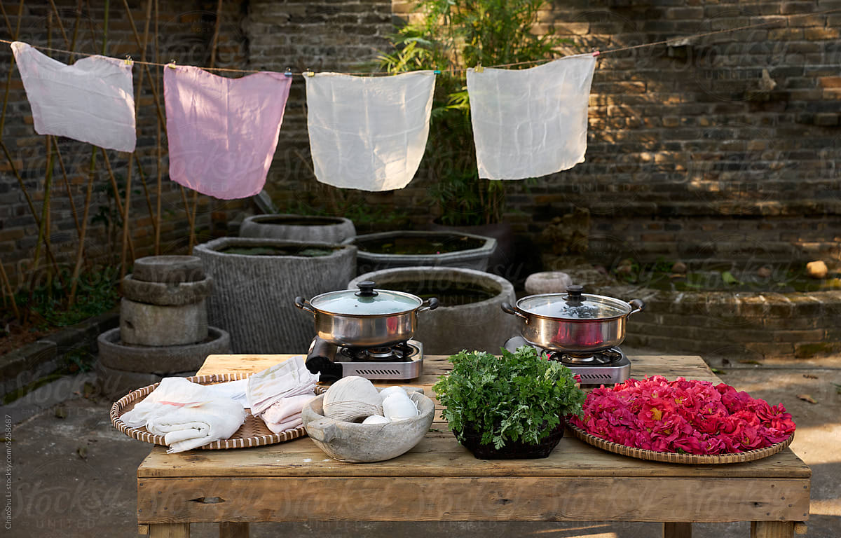 A table full of materials and tools for dyeing cloth, in the yard