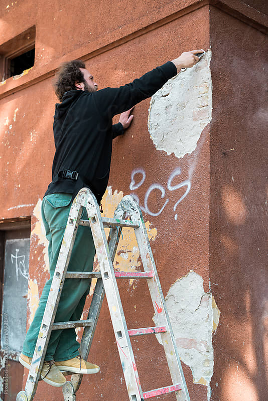 Graffiti artist preparing wall for painting