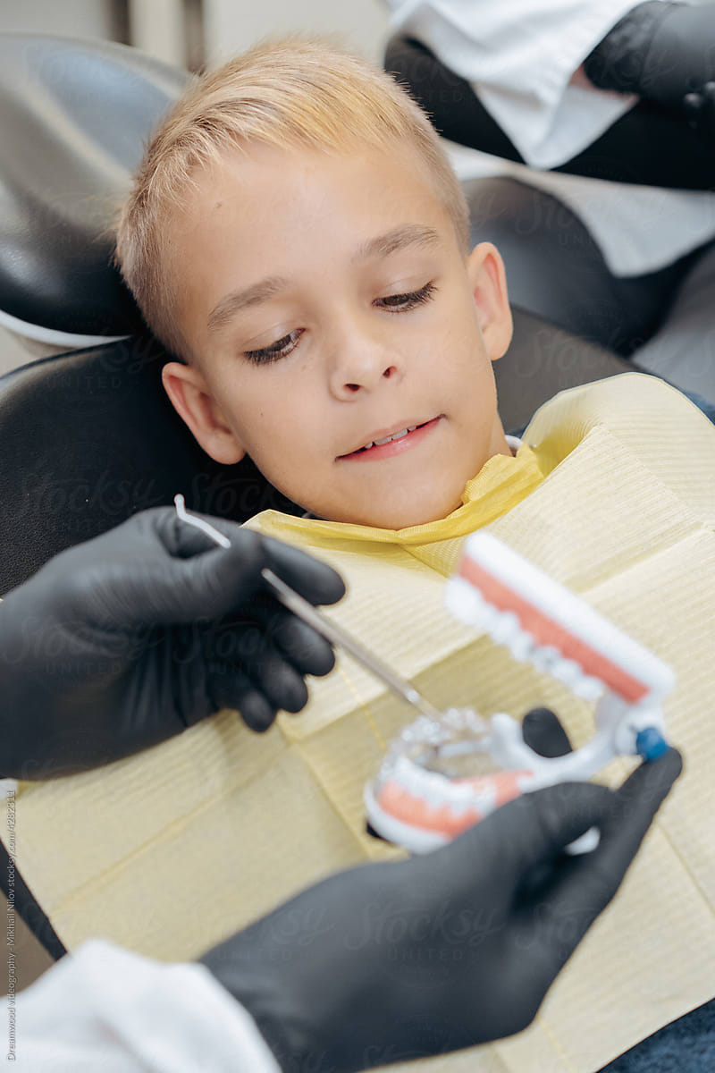 Dentists examine a young patient with instruments