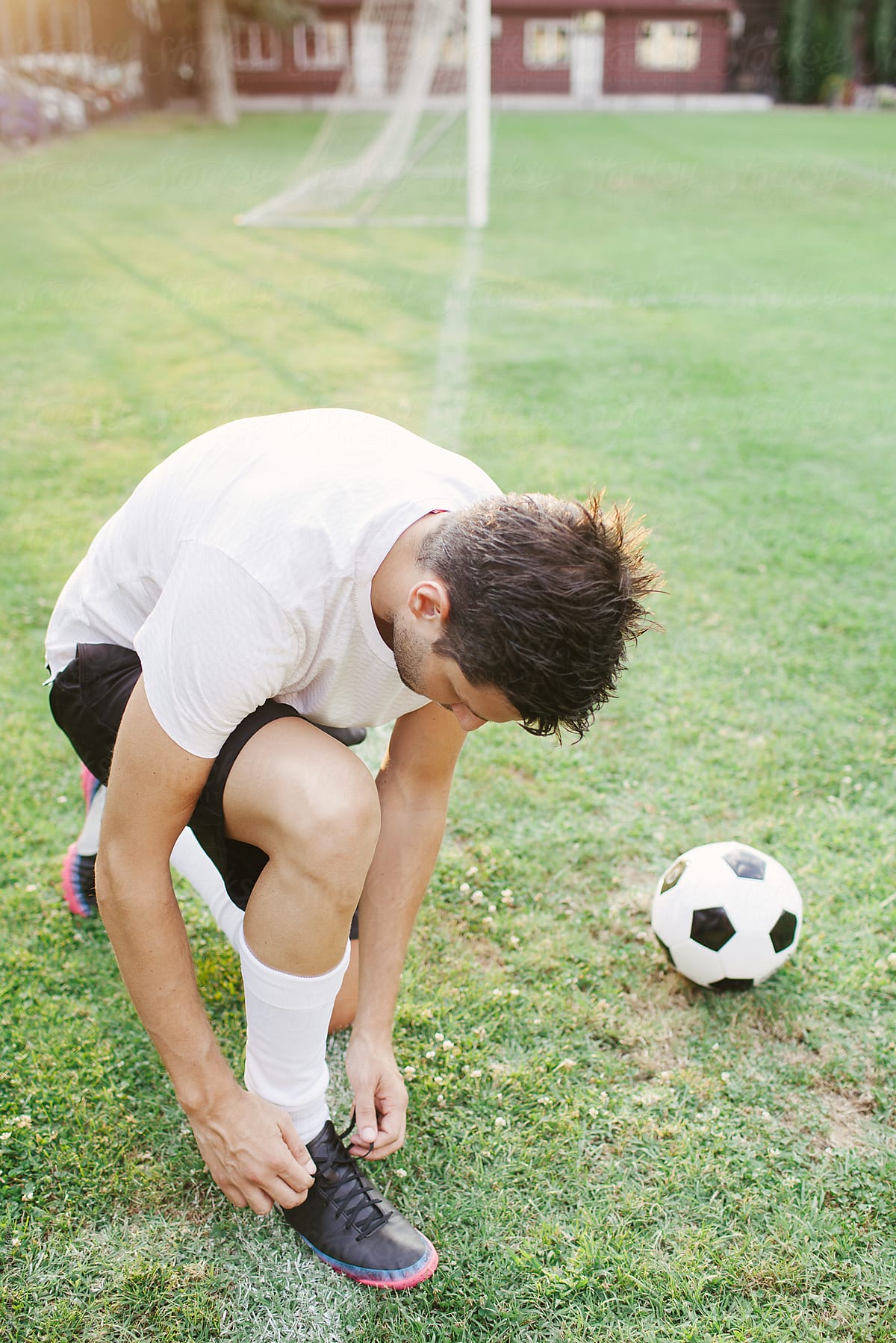 Football player tying his soccer sneakers
