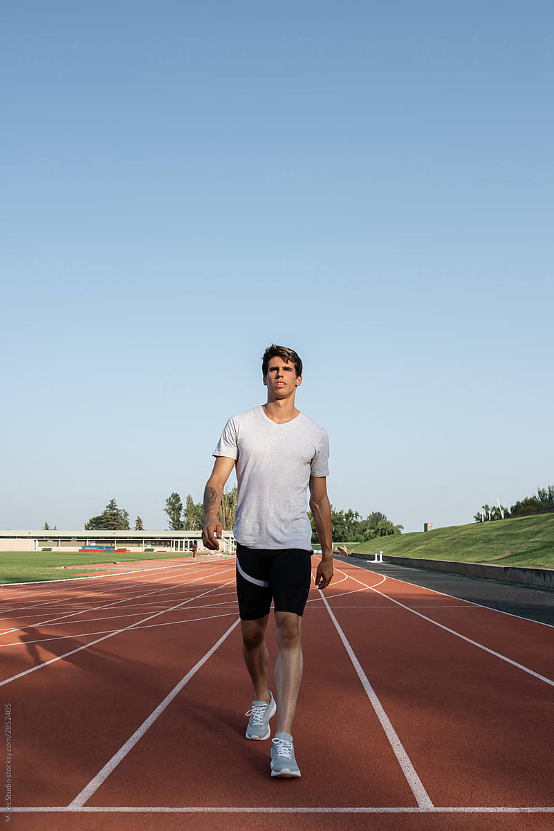 Serious athlete walking on track recovering breath