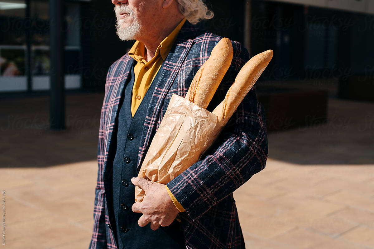 Man holding a bag with baguettes