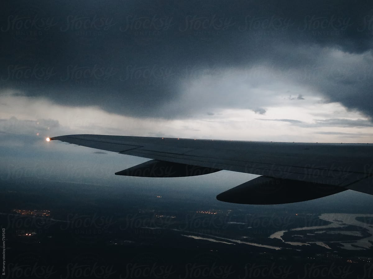 On a Plane Overlooking Storm Clouds as the Sun Sets