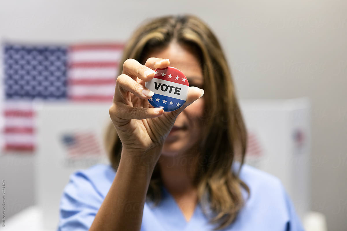 Election: Woman Holds Vote Pin In Front Of Face